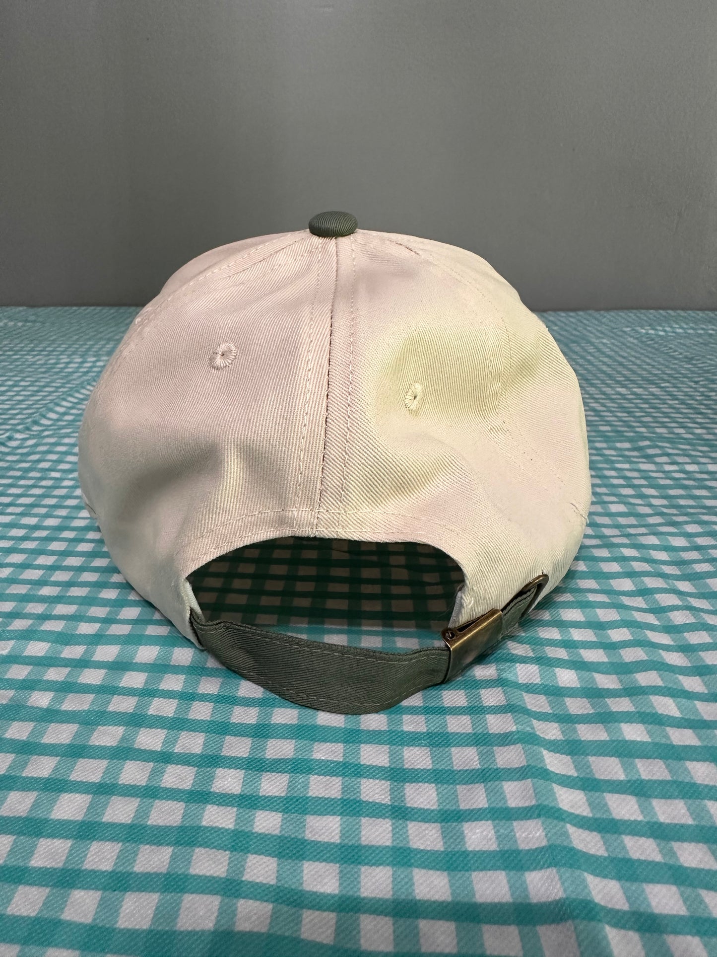 Beige cap with a checkered pattern on a textured surface