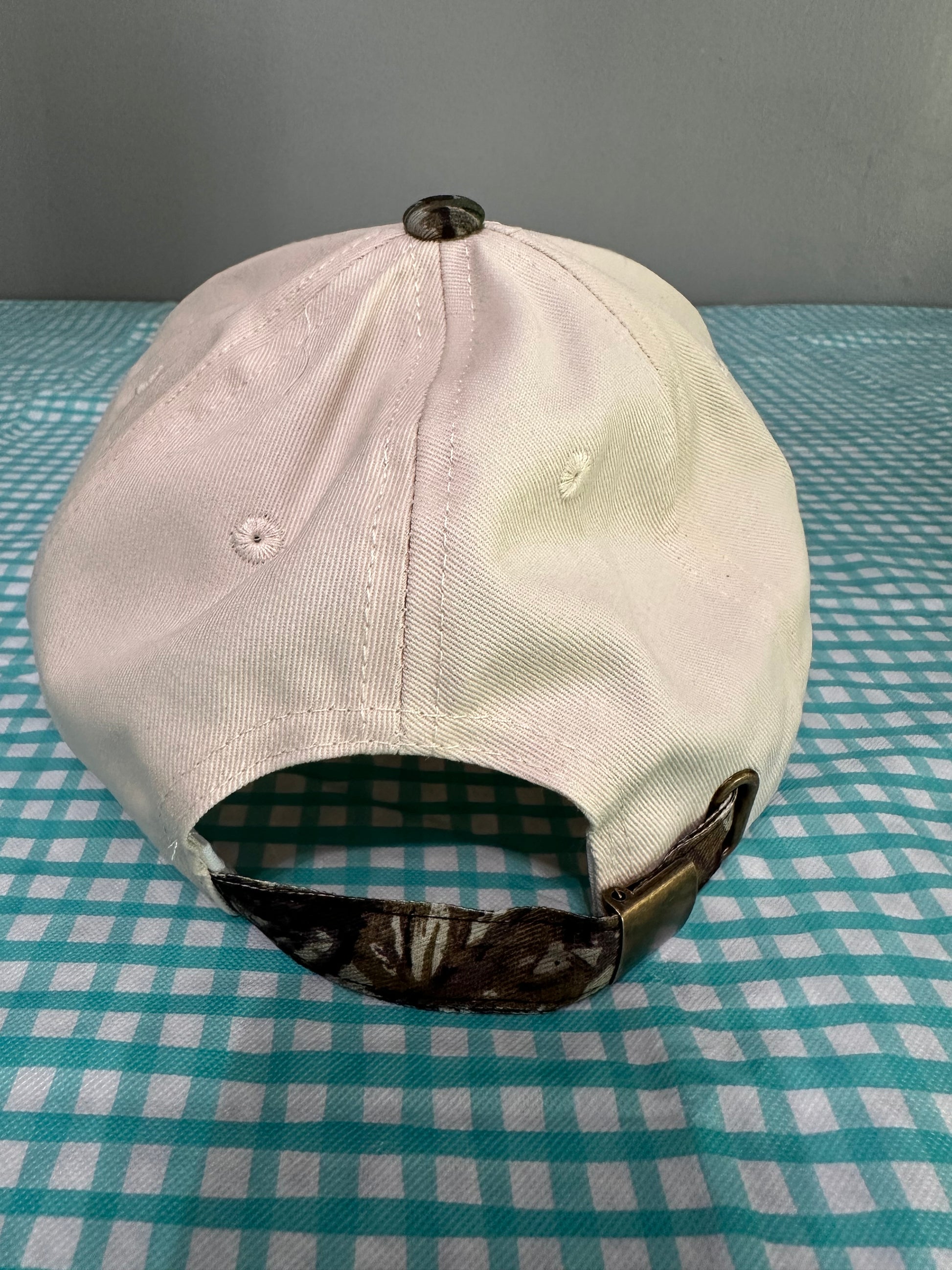 White cap with black strap on a checkered background